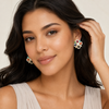 Latina model tucking hair, Swarneva multi-gemstone earrings, colorful sparkle and pearl accents