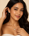 Woman wearing a necklace and earrings against a beige background
