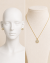 Gold jewelry set on a mannequin and necklace display