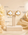Swarneva gold-tone stainless steel crystal floral bloom stud earrings on display, 14mm x 14mm, weight 3.8 grams