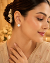 Swarneva gold-tone stainless steel crystal floral bloom studs, 14mm x 14mm, styled on Indian model