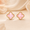 Pair of pink clover-shaped earrings with gold frames on a beige fabric background