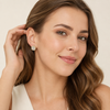 European model tucking hair, Swarneva Aurelia Emerald-Cut Earring, two-tone metal and pave halo sparkle