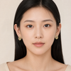 Woman wearing gold earrings against a beige background