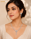 Swarneva Luminary Petal Necklace & Earrings Set worn by Indian female model, silver-tone floral jewelry with clear stones, necklace 220 x 30 mm and earrings 35 x 18 mm.