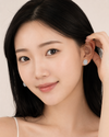East Asian model tucking hair, Swarneva Micro-Pave Oval Solitaire Earring, tiny pave diamonds sparkle around center