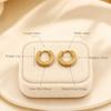 Swarneva gold-tone stainless steel clear stone hoop earrings on display, 14mm x 14mm, weight 4.1 grams