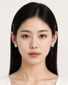 Woman wearing diamond earrings against a white background