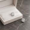 Silver ring with emerald-cut gemstone on a gray marble surface