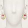 Gold earrings with pink gemstones on a mannequin ear