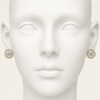Gold earrings with a large round gemstone on a mannequin head.