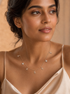 Swarneva Multi-Charm Snake Rose Gold Necklace worn by Indian model collarbone, rose gold snake charm necklace editorial