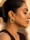 Swarneva Vortex Statement Studs worn by Indian model profile ear, gold multi-oval swirl statement earrings editorial